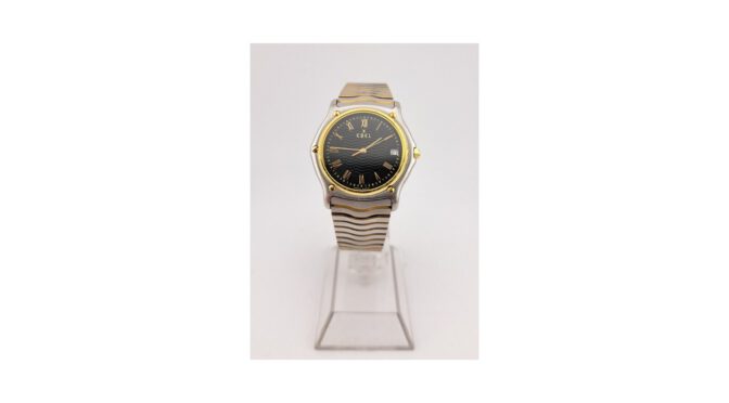 Horloge, Ebel – Classic 1911 wave, quartz, 18k gouden lunet en kastschroeven.